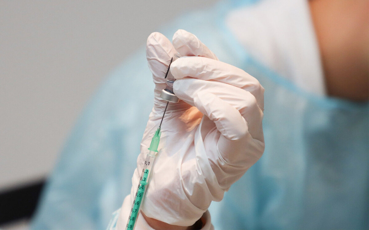 Impfung Spritze gegen das Coronavirus wird aus Fläschchen gezogen Impfung Spritze gegen das Coronavirus wird aus Fläschchen gezogen